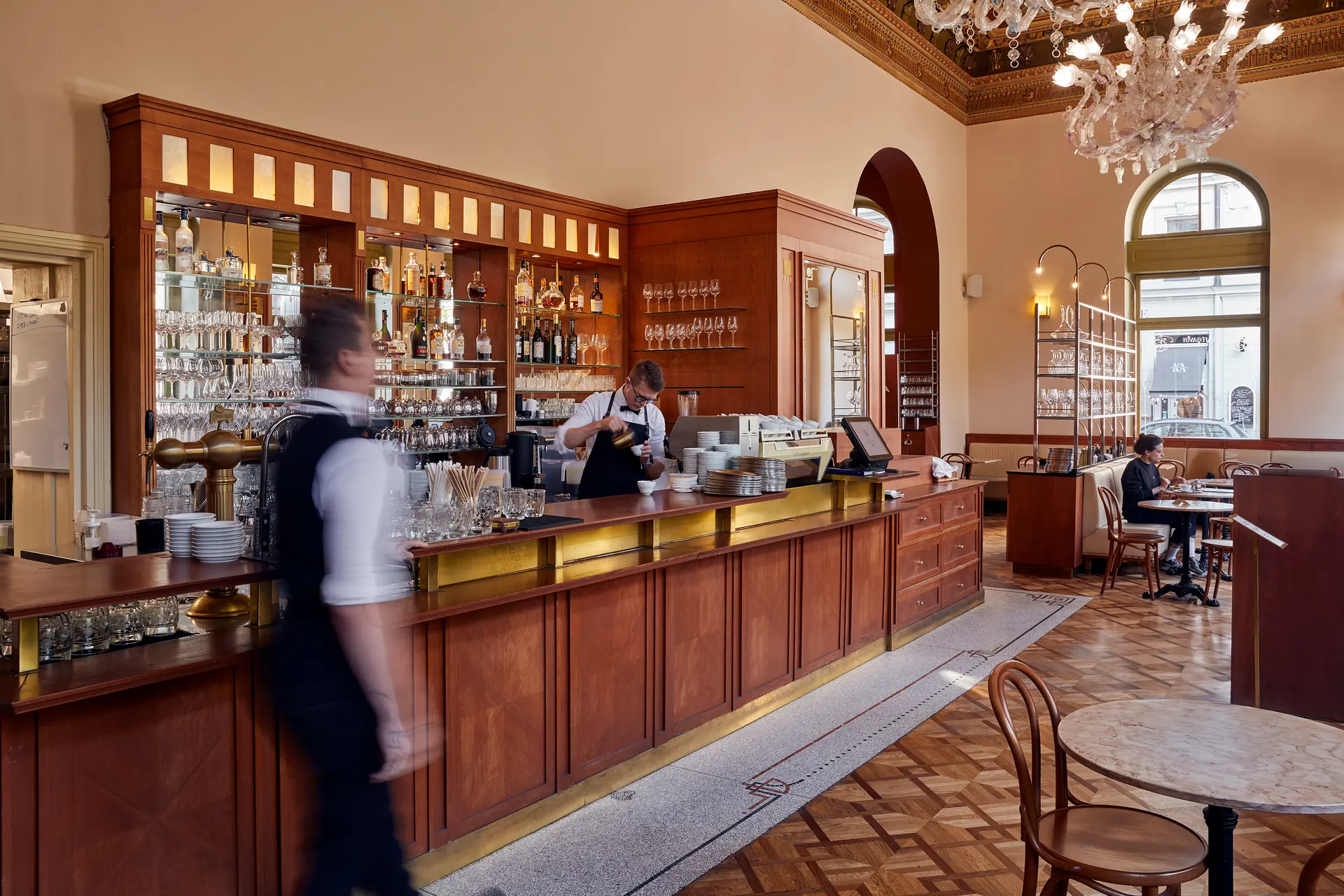 Bar and interior of Savoy Restaurant and Café with staff in motion.